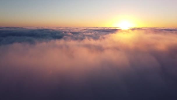 Sol anaranjado en el horizonte e inmersión en la espesa niebla matutina, volando en las nubes sobre un dron. — Vídeo de stock