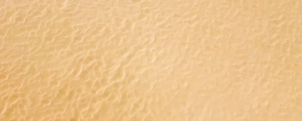 Vista superior sobre un patrón de playa limpia de arena marina. Fondo panorámico con textura. — Foto de Stock