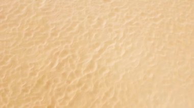 Temiz kumlu arka plan, deniz yaz plajının dokusu, tüm sahili kaplayan kumun üst manzarası..