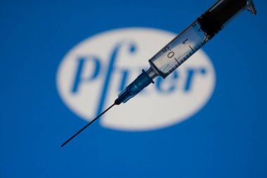 Kyiv, Ukrayna 4 Ocak 2020. Covid-19 'a karşı Pfizer aşısı, Pfizer' dan ilaç konsepti. Şırınganın arka planında şirket imzası var..