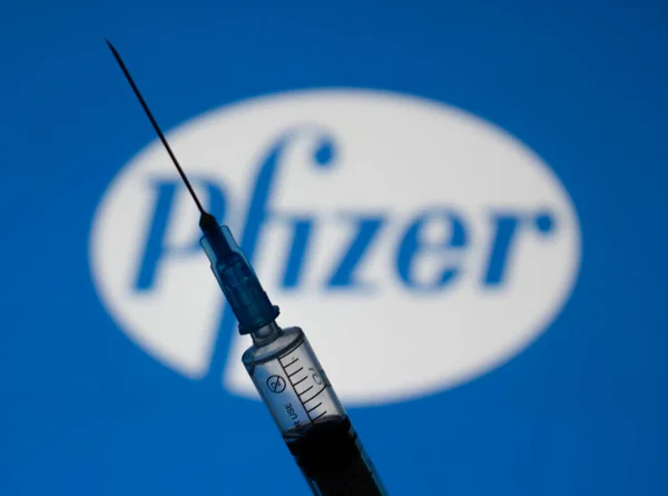 Kyiv, Ukrayna 4 Ocak 2020. Covid-19 'a karşı Pfizer aşısı, Pfizer' dan ilaç konsepti. Şırınganın arka planında şirket imzası var..