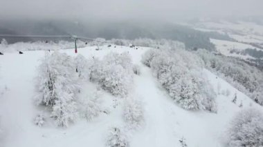 Tatilcilerin kayak ve snowboard yaptığı kayak merkezinin en üst manzarası. Asansör insanları en tepeye çıkarır..