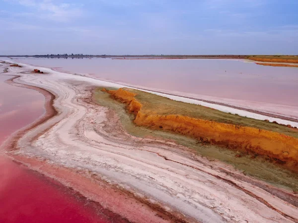 Top view of a pink lake. The narrow shore separating the lake and the sea bay. Pink lake with high salt content.