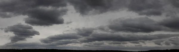 Dark clouds in the gray sky, a panorama of gloomy weather to the horizon