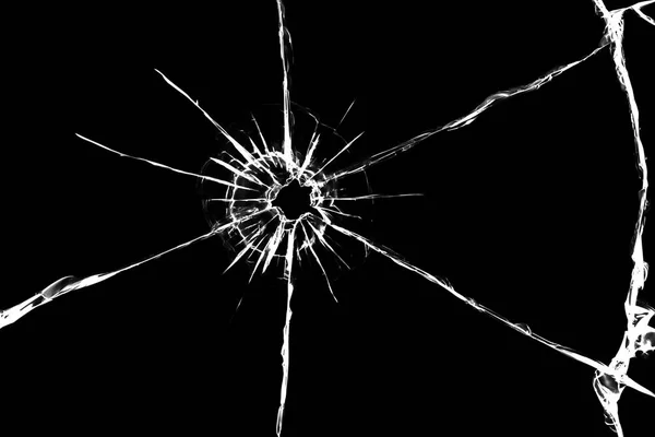 Texture of cracks on the glass from the shot. Cracked glass for design. Cracks on a black background.