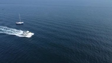 Mavi denizin dalgalarında beyaz bir tekne yüksek hızda yarışıyor. Bir sürat teknesinde dinlenin dalgaların üzerinde