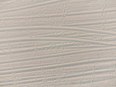 İzleri ve ayak izleri olan kumsal kumu. Denizde kumlu sahil