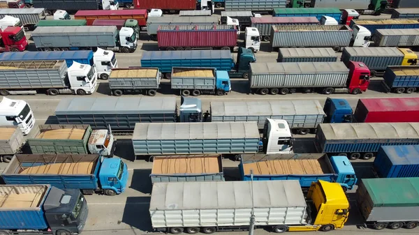 Trucks with containers and trailers in the port are waiting to be unloaded