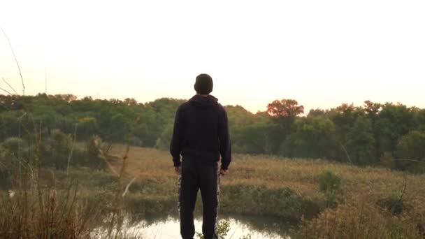 Atleet nadert rand, ziet er meer, bomen platteland in de natuur — Stockvideo