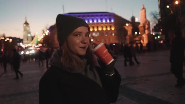 Girl with coffee in the main square, burning lights city, winter holidays — Video