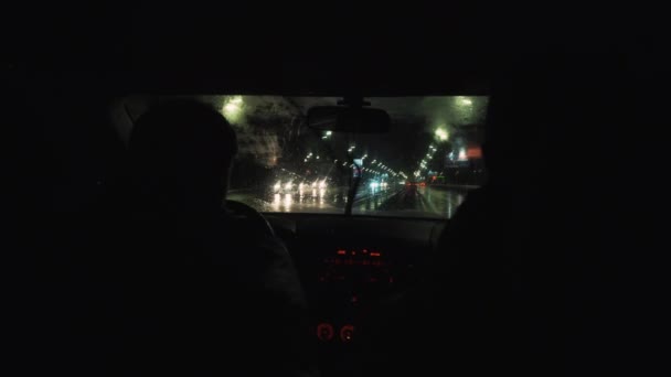 O carro dirige através da cidade da noite na chuva — Vídeo de Stock