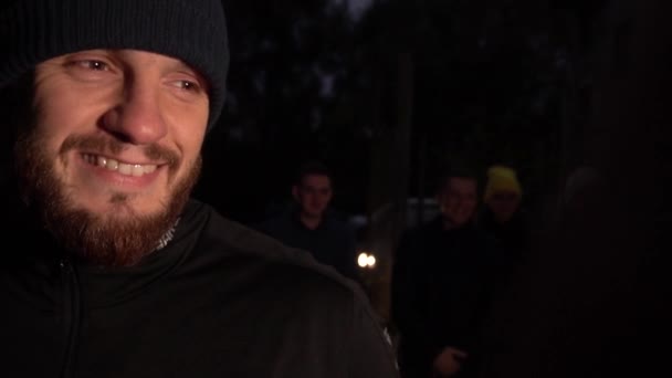 Young man with beard night on the street looks close the camera and smiles — Stock Video