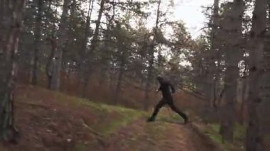 Bir atlet karanlık kozalaklı ormanda çok hızlı koşar.