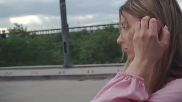 Meisje met wankel haar loopt alleen op onvoltooide brug — Stockvideo