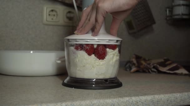 A menina mistura queijo cottage e morangos em um liquidificador — Vídeo de Stock