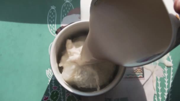따끈 한 우유를 컵에 담긴 초콜릿 공에 붓는다 — 비디오