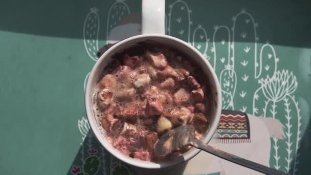 Uma colher de chá de pernas longas mistura lentamente os marshmallows marrons em uma xícara — Vídeo de Stock