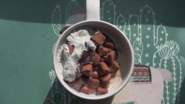 Çok renkli şekerlemeler bir bardak sıcak sütün içinde ortaya çıkar.