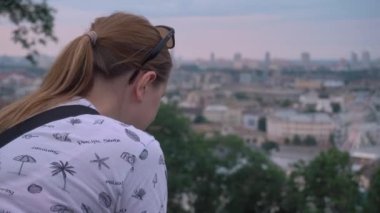 Kiev - Ukrayna Temmuz 2021 Çok renkli saçlı bir kız şehrin arka planına bakıyor