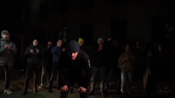 Young guy looking intently at the camera at night on the street — Stock Video