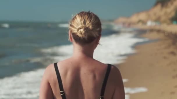 Sanzheyka - Oekraïne augustus 2020 blond meisje loopt in de ochtend op het zand aan de Zwarte Zee kust — Stockvideo