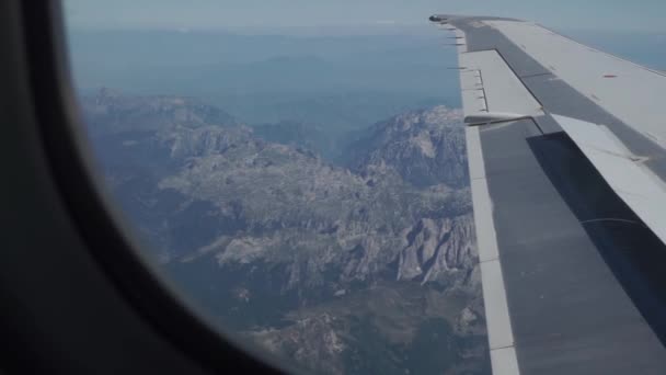 Asa do avião voa sobre o relevo rochoso, montanhas negras de Montenegro — Vídeo de Stock