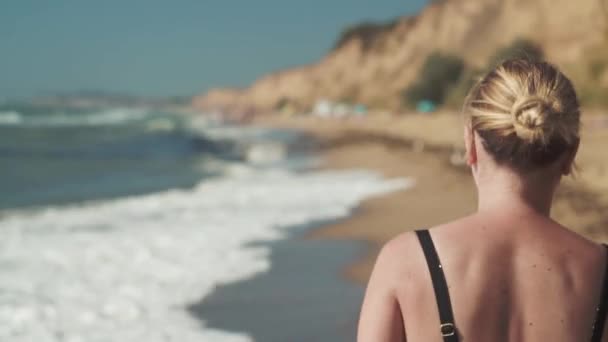 Sanzheyka - Ucrânia agosto 2020 menina loira caminha de manhã na areia na costa do mar preto — Vídeo de Stock