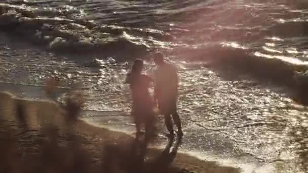 Een getrouwd stel met een klein kind in hun armen maakt familiefoto 's aan zee — Stockvideo