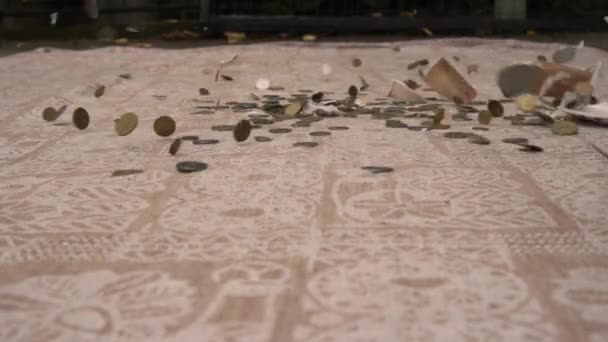 De keramische spaarpot valt van een hoogte en breekt, munten scatter op de vloer — Stockvideo