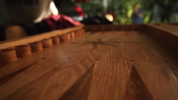 Un homme lance des dés sur une planche de bois avant de jouer au backgammon — Video