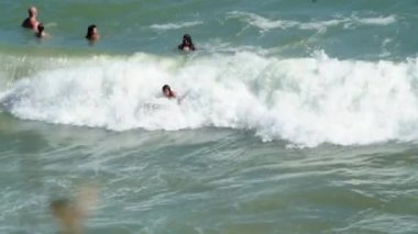 Yan taraftan çekilen genç kızlar Karadeniz 'deki büyük dalgalarda sörf yapmanın keyfini çıkarıyorlar.