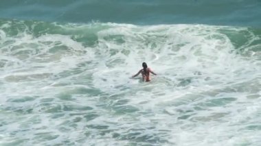 Siyah mayo giyen genç kızlar denizde rahatlayıp yüzmekten zevk alırlar.