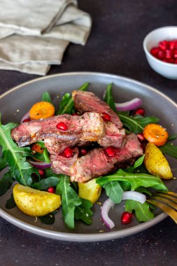 Izgara biftek salatası, roka, patates, havuç, soğan ve nar. Sağlıklı beslenme. Diyet