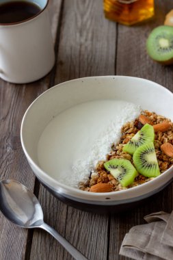 Beyaz yoğurtlu müsli, kivi ve hindistan cevizi. Sağlıklı beslenme. Vejetaryen yemeği. Kahvaltı.
