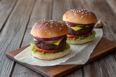 Et, domates, salatalık, peynir ve soğanlı hamburger. Amerikan mutfağı. Fast food