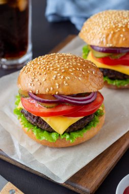 Pirzola, domates, marul, salatalık, soğan ve peynirli hamburger. Amerikan mutfağı Fast Food Cheeseburger