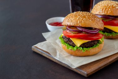 Pirzola, domates, marul, salatalık, soğan ve peynirli hamburger. Amerikan mutfağı Fast Food Cheeseburger