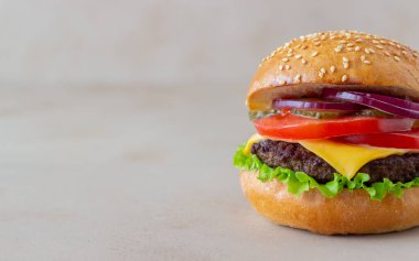 Pirzola, domates, marul, salatalık, soğan ve peynirli hamburger. Amerikan mutfağı Fast Food Cheeseburger