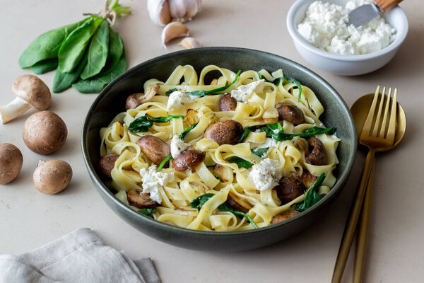 Linguine pasta с грибами, белым сыром, шпинатом и чесноком. Здоровое питание. Вегетарианская еда. Диета