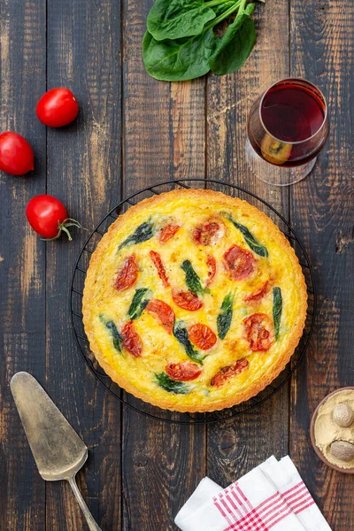Quiche or pie with tomatoes, spinach and cheese. Healthy eating. Vegetarian food. French cuisine
