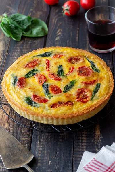 Quiche or pie with tomatoes, spinach and cheese. Healthy eating. Vegetarian food. French cuisine