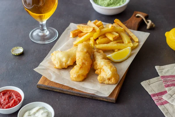 Fish and chips on a dark background. British fast food. Recipes. Snack to beer. Traditional british food.