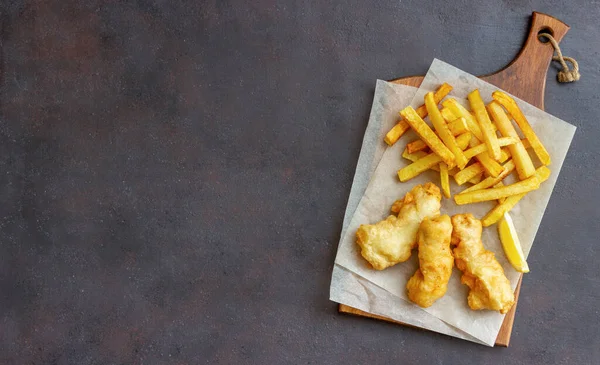 Fish and chips on a dark background. British fast food. Recipes. Snack to beer. Traditional british food.