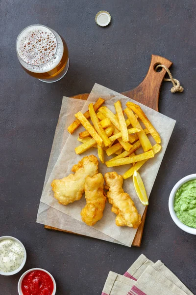 Fish and chips on a dark background. British fast food. Recipes. Snack to beer. Traditional british food.