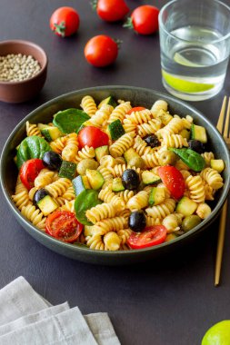 Domatesli makarna salatası, kabak, zeytin ve ıspanak. Sağlıklı beslenme. Vejetaryen yemeği.