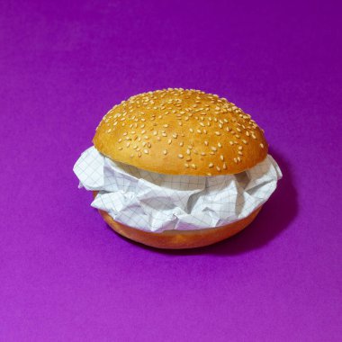 Mor zemin üzerinde kağıt olan bir hamburger. Soyutlama. Fikir.