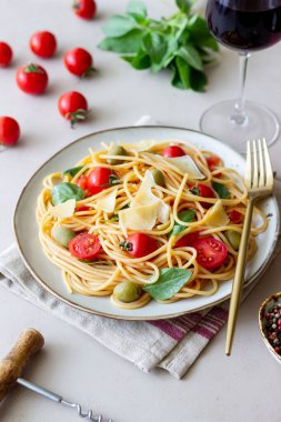 Domatesli spagetti makarna, fesleğen, zeytin ve parmesan peyniri. Sağlıklı beslenme. Vejetaryen yemeği.