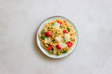 Domatesli spagetti makarna, fesleğen, zeytin ve parmesan peyniri. Sağlıklı beslenme. Vejetaryen yemeği.