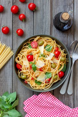 Domatesli spagetti makarna, fesleğen, zeytin ve parmesan peyniri. Sağlıklı beslenme. Vejetaryen yemeği.