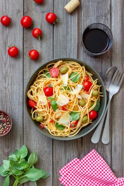 Domatesli spagetti makarna, fesleğen, zeytin ve parmesan peyniri. Sağlıklı beslenme. Vejetaryen yemeği.